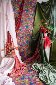 three different colored curtains with flowers in the middle and one on the floor next to it