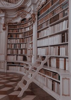 a room with many bookshelves filled with lots of books and a stair case