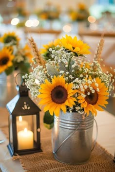 sunflowers and baby's breath flowers in a metal pail on a table