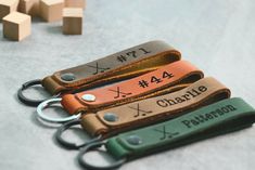 three personalized leather keychains sitting on top of a table