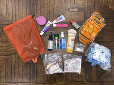 an assortment of personal care items laid out on a wooden floor