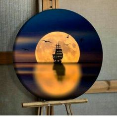 an image of a full moon with a boat in the water