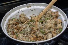 a white bowl filled with food and a wooden spoon in it on top of a stove