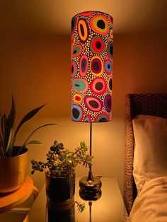 a lamp that is on top of a table next to a plant and potted plants