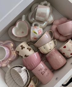 a drawer filled with lots of pink and white cups