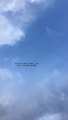 an airplane flying in the sky with some writing on it's side and clouds