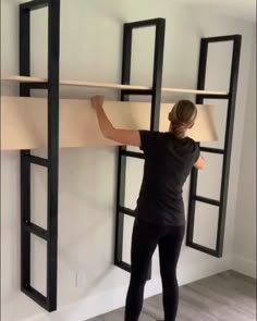 a woman is standing in front of an open window and she has her hands on the ledge