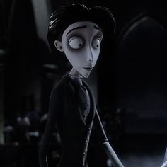 the animated character is dressed in black and holding a white object with one eye on it