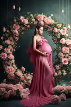 a pregnant woman in a pink dress standing next to flowers