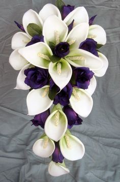 a bouquet of white and purple flowers on a gray background