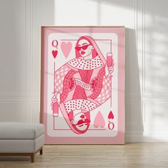 a pink and white ace playing card on a wall next to a chair in a room