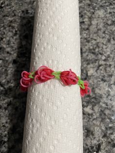 a white napkin with red and green braiding on it sitting on a counter top