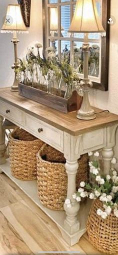 a table with baskets and flowers on it in front of a mirror that is reflecting the light