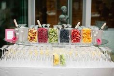 a table topped with wine glasses filled with different types of fruits and veggies