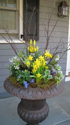 a potted planter with flowers and plants in it on the front porch area