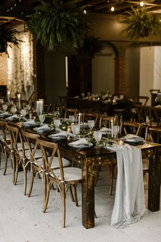 the tables are set with white linens and place settings for guests to sit at