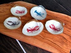 four red and blue lobsters are sitting on a wooden tray