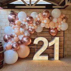 the number twenty one is surrounded by balloons and streamers in front of a brick wall