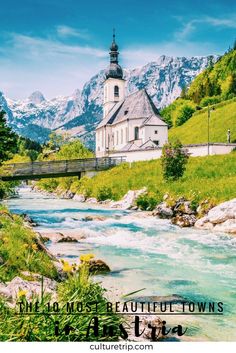 a river running through a lush green hillside next to a church