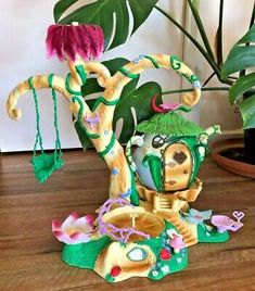 a figurine sitting on top of a wooden table next to a potted plant