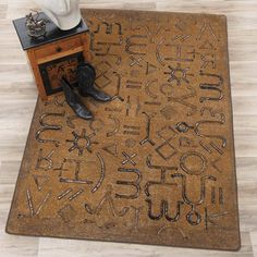 a brown door mat with black letters and cowboy boots sitting on it next to a white hat