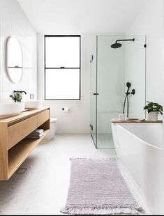 a white bathroom with a sink, toilet and bathtub in the middle of it