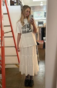 fake blonde girl trying on a white maxi skirt going until the feet, paired with a white graphic tee and black doc martens boot, taking a slefie in the mirror Nyc Winter Outfits, Nyc Winter, Look Grunge, White Long Skirt, Long Skirt Outfits, Maxi Skirt Outfits, School Looks