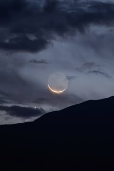 the moon and venus are seen through dark clouds