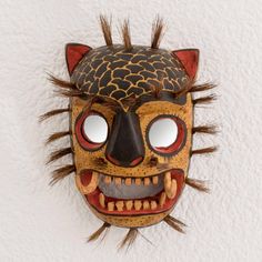 With round staring eyes and a fearsome mouth the face of a jaguar is hand-carved from a single piece of pinewood which is accented with tufts of natural agave fiber. Guatemalan duo Juan and Carolina create this mask for a stunning addition to any home. A cord of agave fiber on the back allows this mask to be hung from a wall. Elephant Mask Art, Jaguar Skull Mask, Paper Mache Tiki Mask, Aztec Mud Mask, Gourd Masks, Staring Eyes, Jaguar Mask, Flash Ideas, Mexican Mask