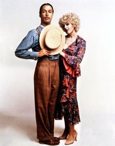 a man and woman standing next to each other with hats on their heads, in front of a white background