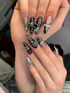 Long acrylic nails painted black with silver details and charms Acrylic Nails Rockstar Girlfriend, Heavy Metal Inspired Nails, Goth Rhinestone Nails, Nail Ideas Rockstar Gf, Grunge Nails With Charms, Emo Nails Y2k, Goth Charm Nails, Black Nail Designs Emo, Nail Rock Style