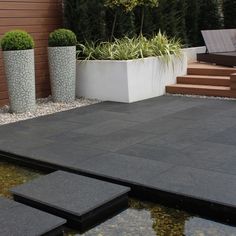 an outdoor patio with steps leading up to the water and potted plants next to it