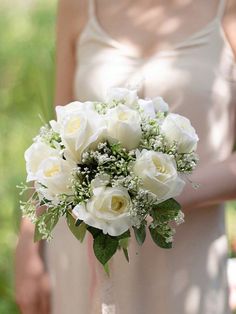 a bridal bouquet with white roses and greenery