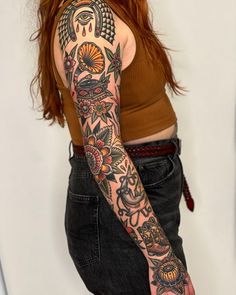 a woman with red hair and tattoos on her arm