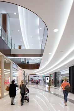 people are walking through the mall with shopping bags