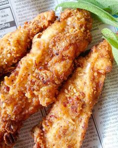 some fried food is sitting on top of a newspaper next to a sprig of leaves