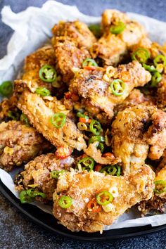 chicken wings with green onions and peppers on a plate