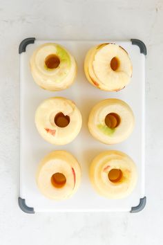 four doughnuts on a tray with apple slices