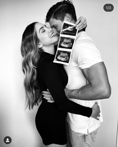 a man and woman kissing each other while holding an appetizer