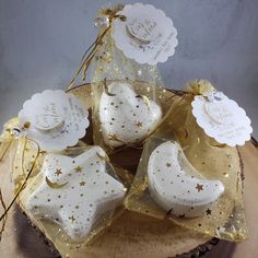 some white and gold decorations on top of a piece of wood with tags attached to them