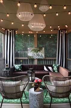 a covered porch with wicker furniture and hanging lights