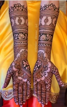 two hands with henna tattoos on their arms and legs, both decorated with intricate designs