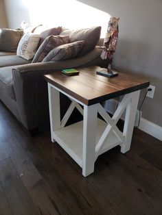 a living room with a couch, coffee table and lamp on the end tables in front of it