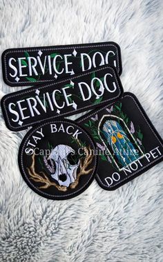 two service dog patches sitting on top of a white fur covered floor next to each other