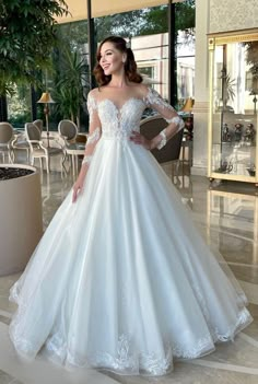 a woman in a white wedding dress posing for the camera