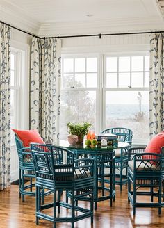 a dining room table and chairs in front of a window with the view of the ocean