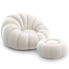 a white chair and ottoman sitting next to each other on a white surface with no one in it