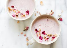 two mugs filled with pink liquid and flowers