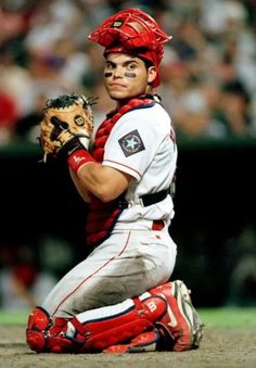 a baseball player sitting on the ground with his catcher's mitt in hand