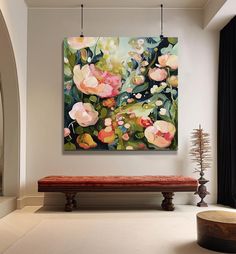 a painting hanging on the wall above a bench in a room with white walls and flooring